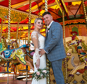 The happy couple on a carousel for their wedding photo at Drayton Manor Resort, Staffordshire
